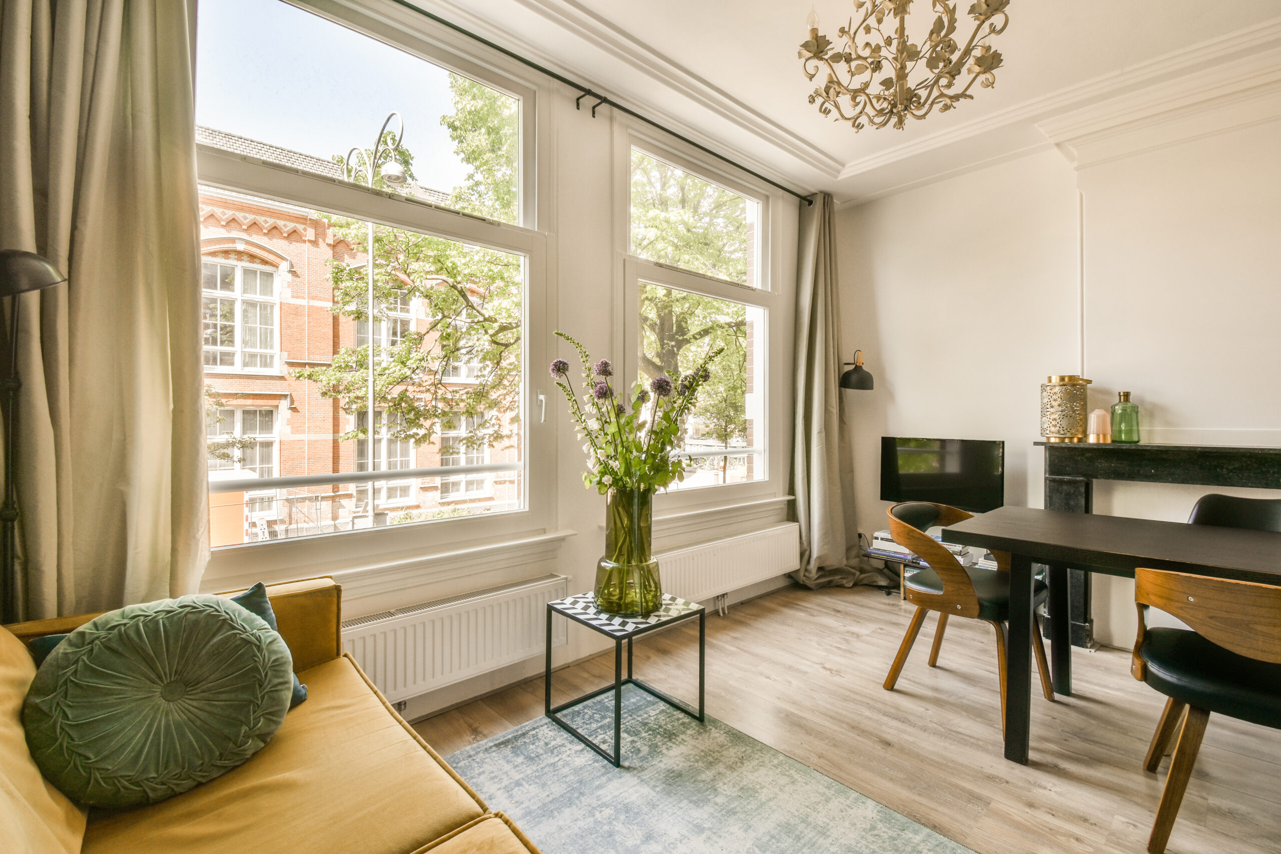 living-room-with-table-chairs-tv-corner-room-looking-out-onto-street